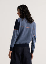 Load image into Gallery viewer, A woman shown from the back wearing a blue and navy striped knit sweater with a solid navy yoke and dark navy wide-leg pants, against a plain light gray studio background.
